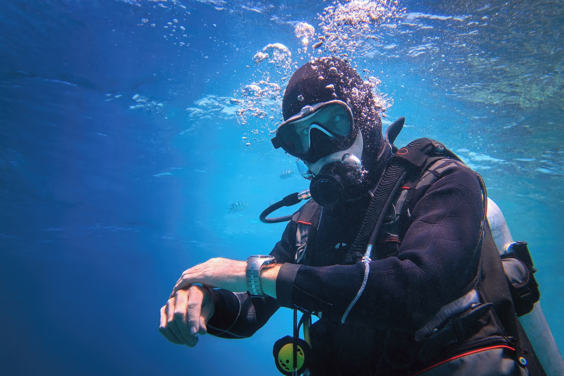 Fully equipped man scuba diver underwater in the blue water