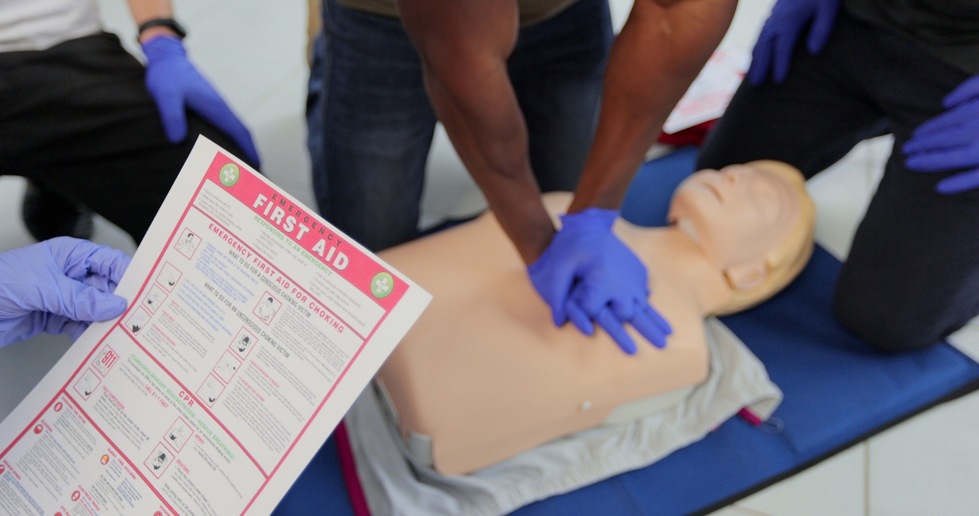 CPR First Aid training concept. Back view of woman holding first aid instruction during cpr training class.